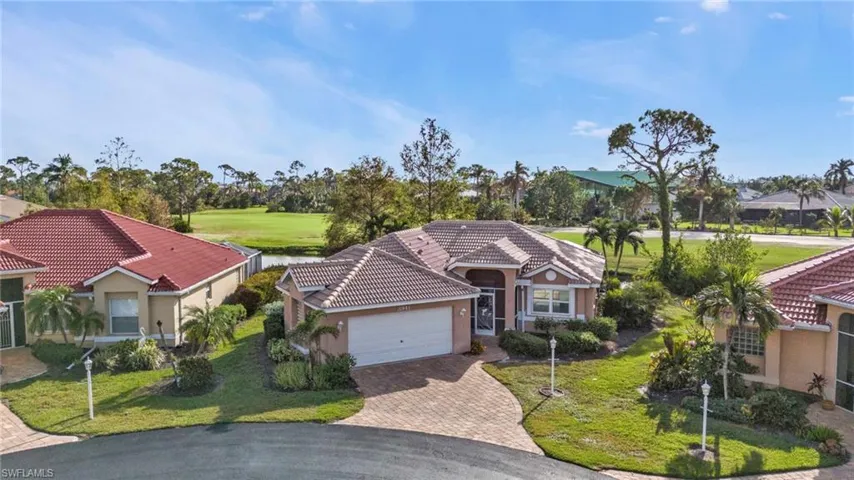 Mediterranean / spanish home featuring a garage and a front lawn