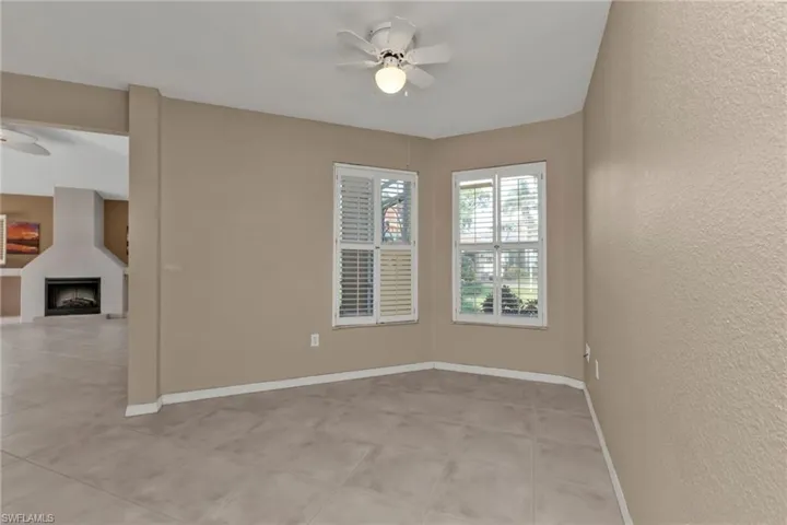 Spare room featuring a fireplace and ceiling fan