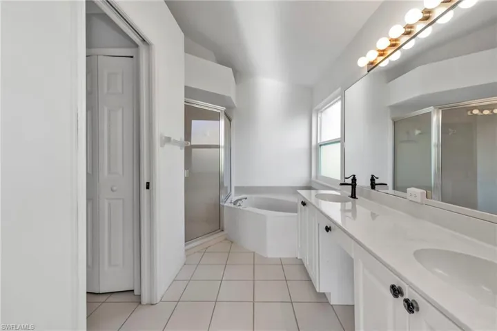 Bathroom with tile patterned floors, separate shower and tub, and vanity