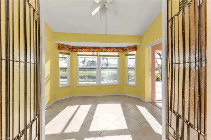 Unfurnished sunroom featuring ceiling fan and lofted ceiling