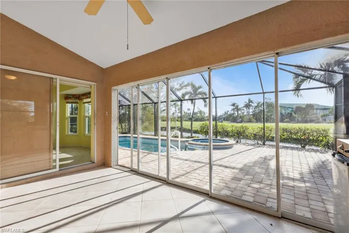 Unfurnished sunroom featuring vaulted ceiling and ceiling fan