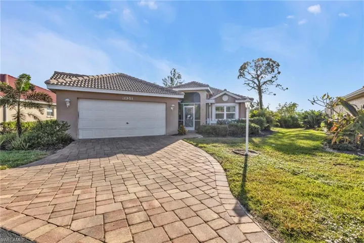 Mediterranean / spanish-style house with a garage and a front lawn