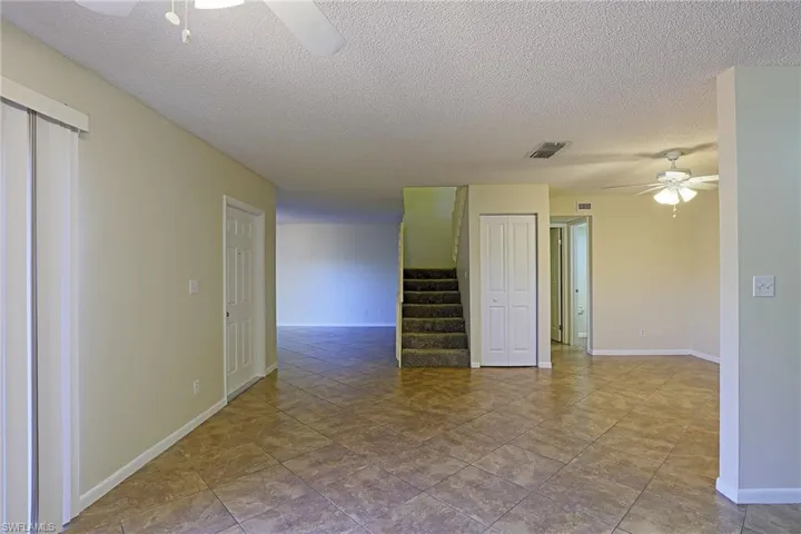 Unfurnished room with a ceiling fan and a textured ceiling