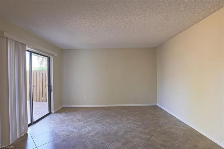 Spare room featuring a textured ceiling and baseboards