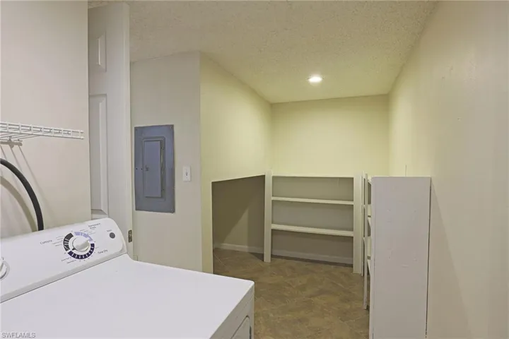 Laundry room featuring washer / dryer, electric panel, recessed lighting, and a textured ceiling