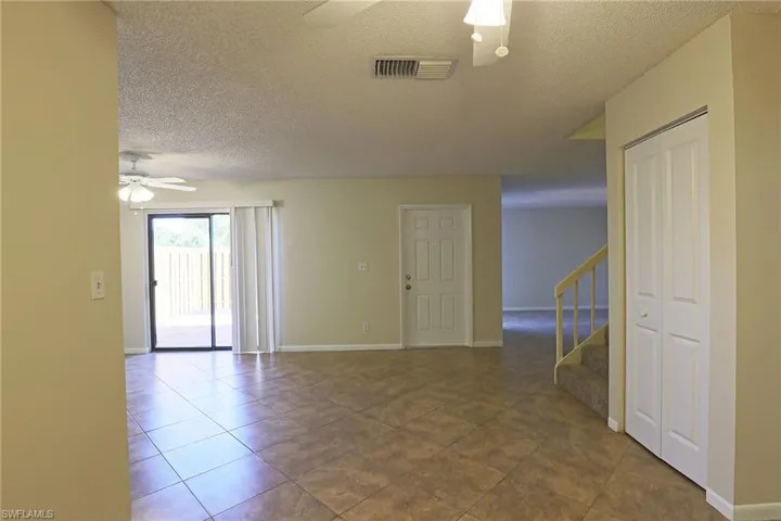 Unfurnished room featuring a ceiling fan, a textured ceiling, and dark tile patterned floors