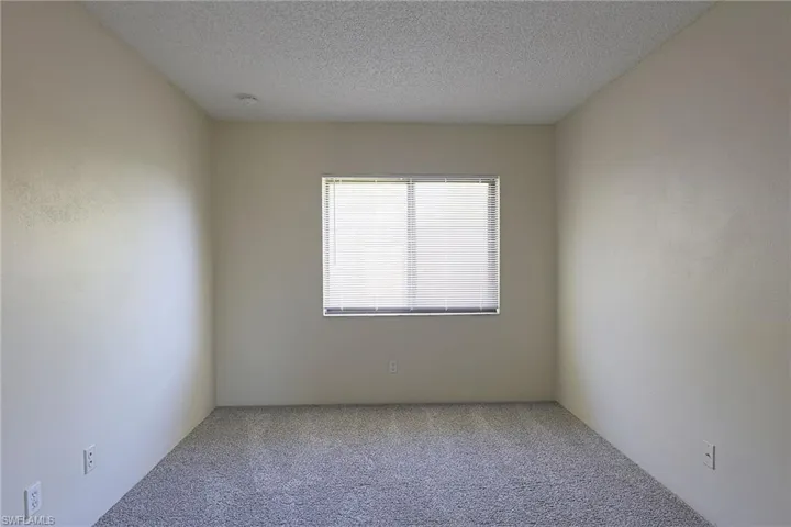 Spare room featuring carpet floors and a textured ceiling