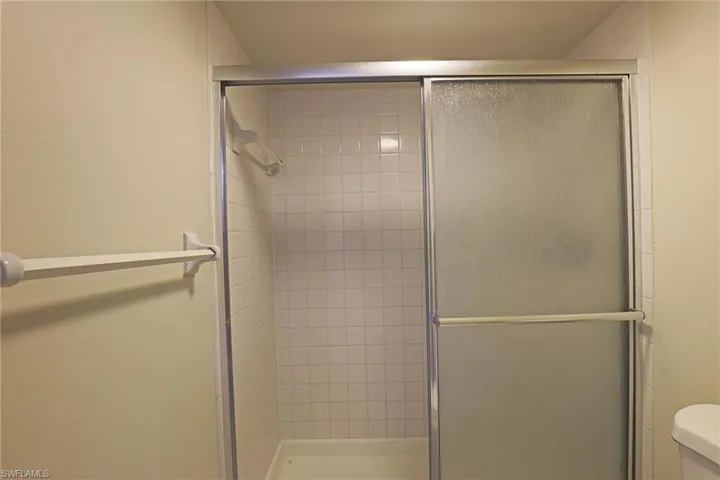 Full bathroom with toilet and a shower stall