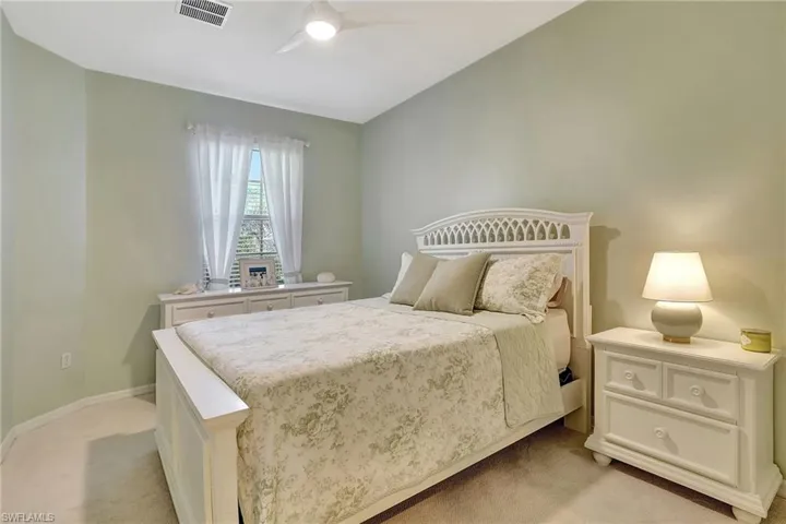 Carpeted bedroom featuring ceiling fan
