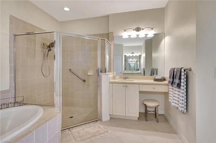 Bathroom featuring vanity, plus walk in shower, and tile patterned flooring