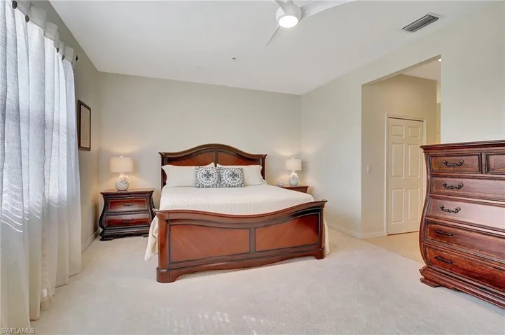 Carpeted bedroom featuring ceiling fan