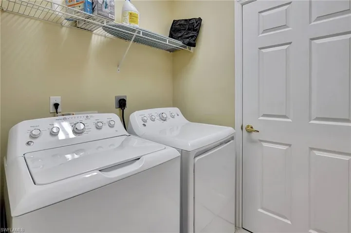 Laundry area with independent washer and dryer and tile patterned floors