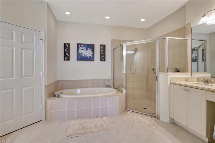 Bathroom with tile patterned flooring, plus walk in shower, and vanity