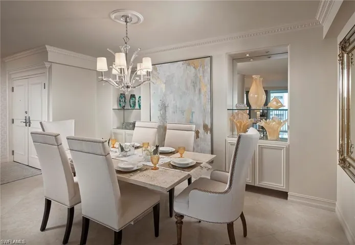 Dining space featuring an inviting chandelier, light tile patterned flooring, and ornamental molding