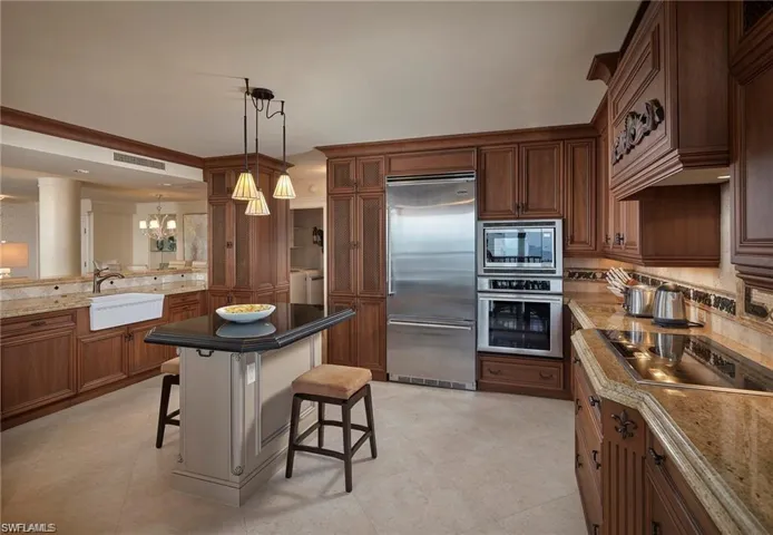 Kitchen with pendant lighting, sink, light tile patterned floors, and built in appliances