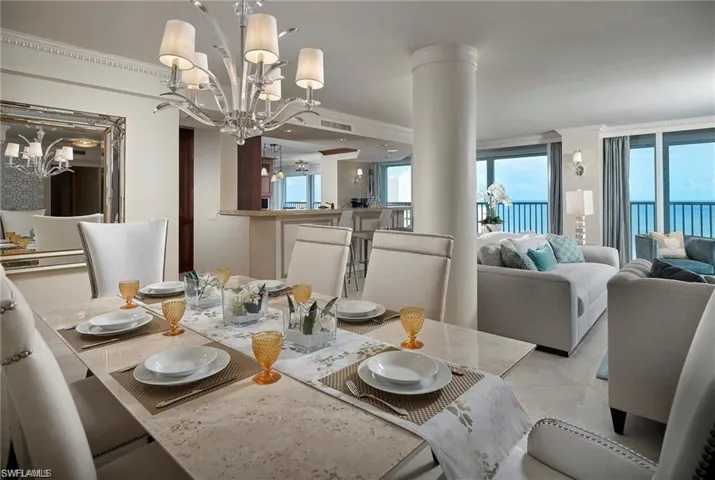 Tiled dining area with plenty of natural light, an inviting chandelier, and ornate columns