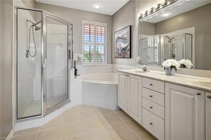 Bathroom featuring independent shower and bath, vanity, and tile patterned flooring
