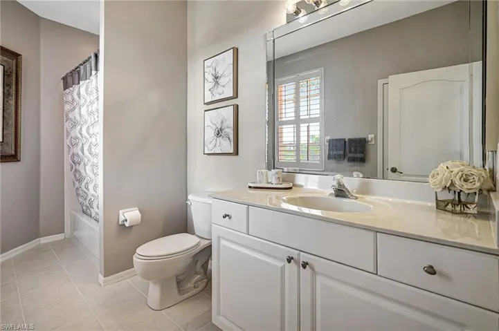 Full bathroom with shower / bath combo, toilet, tile patterned flooring, and vanity