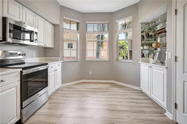 Kitchen with white cabinetry, appliances with stainless steel finishes, and light hardwood / wood-style flooring