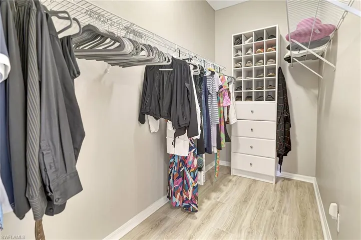 Walk in closet with light wood-type flooring