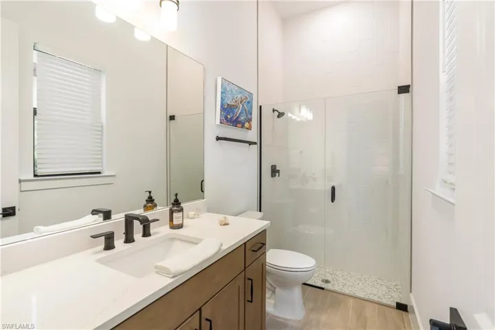 Bathroom with a stall shower, vanity, and light wood-type flooring