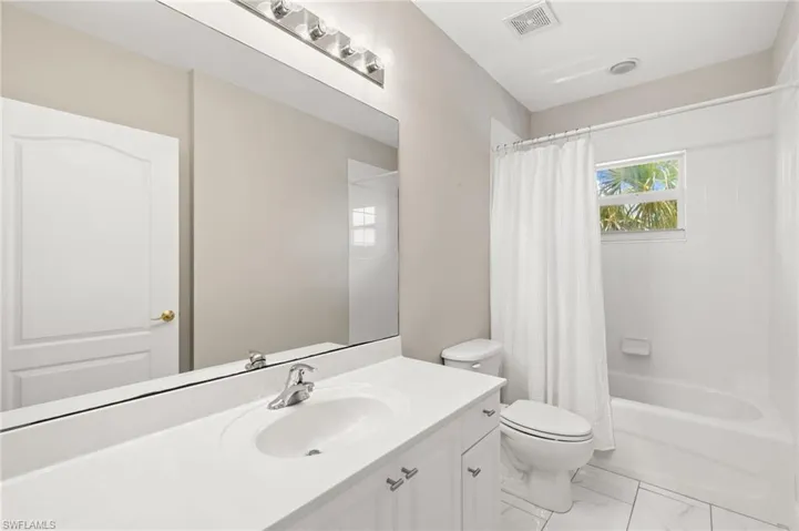 The guest bathroom features a large vanity with plenty of storage and a tub/shower combo.