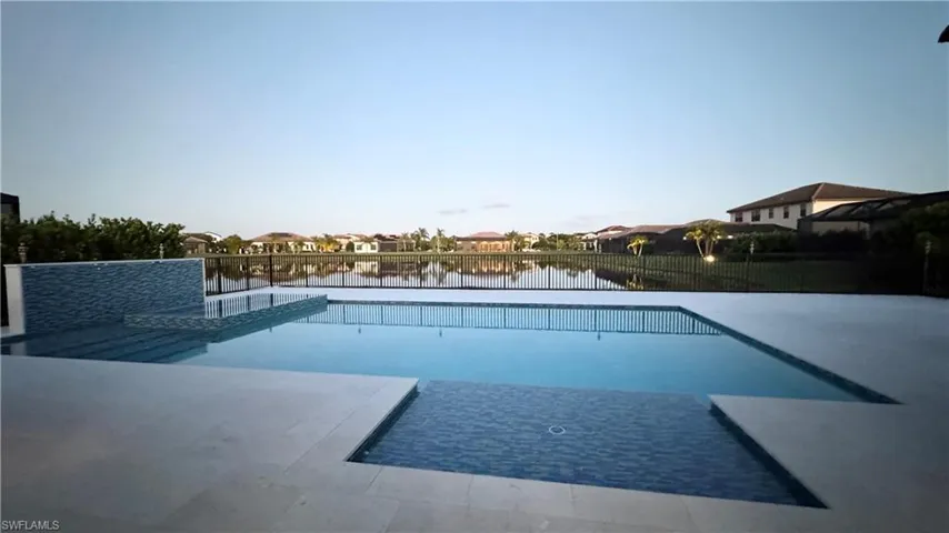 View of swimming pool with a residential view, a water view, and a patio area