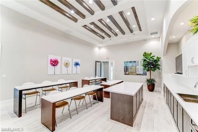 Kitchen featuring beam ceiling, a kitchen island, white cabinetry, and recessed lighting