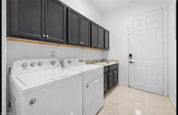 Laundry room featuring cabinet space, independent washer and dryer, and light tile patterned floors