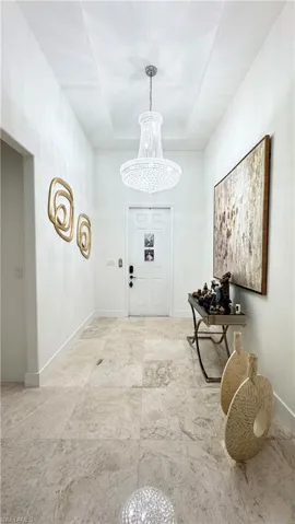 Entrance foyer featuring a chandelier and a tray ceiling