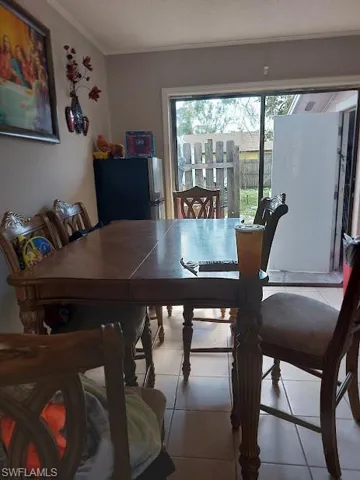 Dining space with ornamental molding and tile patterned floors