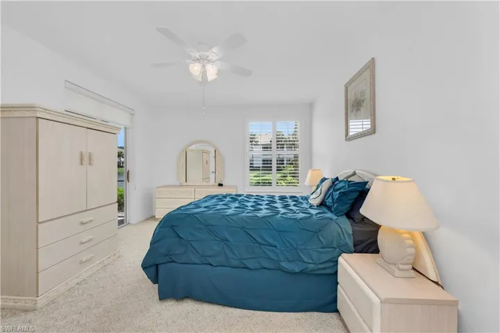 Bedroom 1 featuring light carpet, and a ceiling fan
