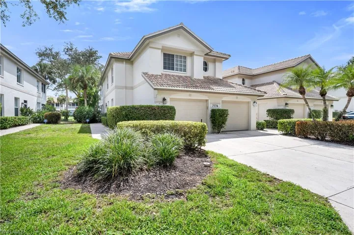 View of front exterior featuring driveway, a tile roof, stucco siding, a front yard, and attached garage