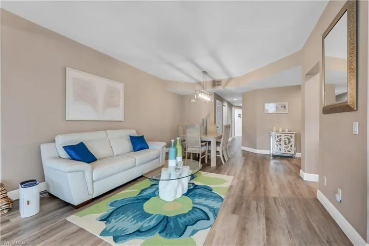 Living area with wood-style LVP floors and a chandelier