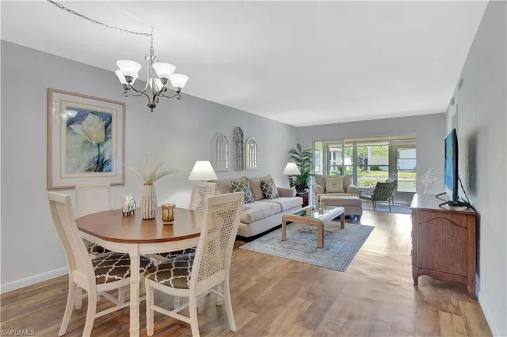 Dining area with a notable chandelier, baseboards, and light wood vinyl floors