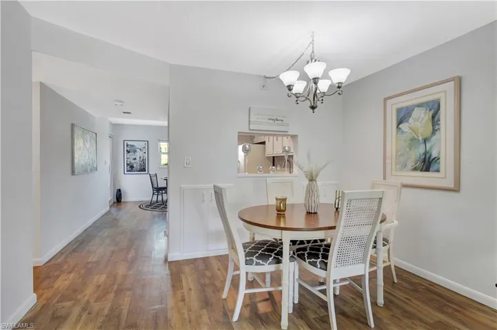 Dining area with a notable chandelier, baseboards, and light wood vinyl floors