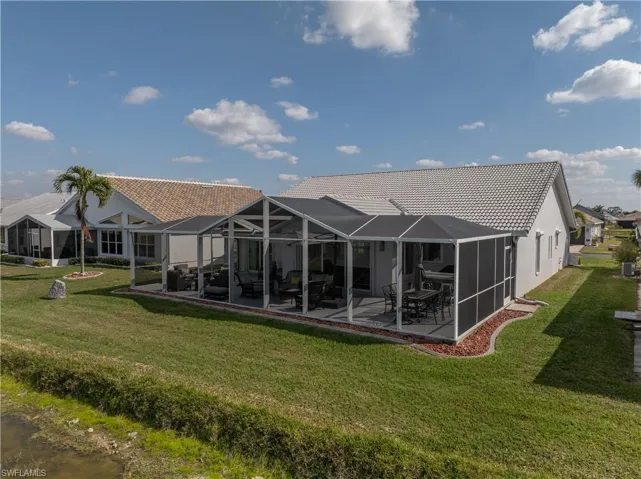 Back of house with a patio, a yard, and glass enclosure