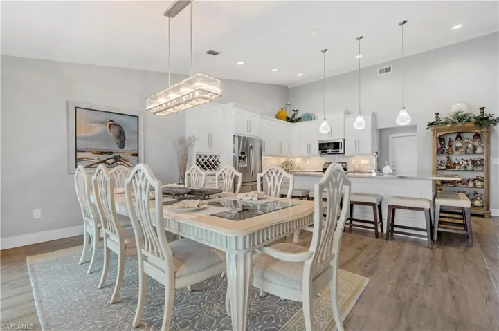 Dining space featuring crown molding, a towering ceiling, hardwood / wood-style floors, and a notable chandelier
