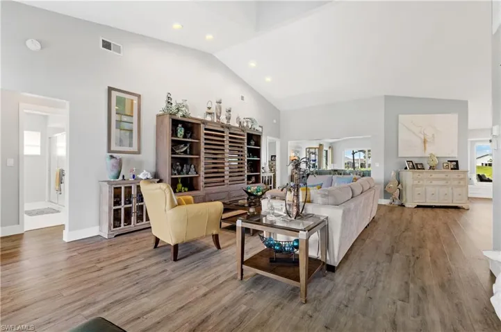 Living room with hardwood / wood-style flooring and high vaulted ceiling