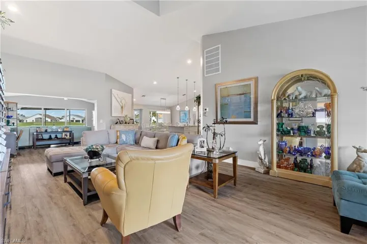 Living room with light hardwood / wood-style flooring and high vaulted ceiling