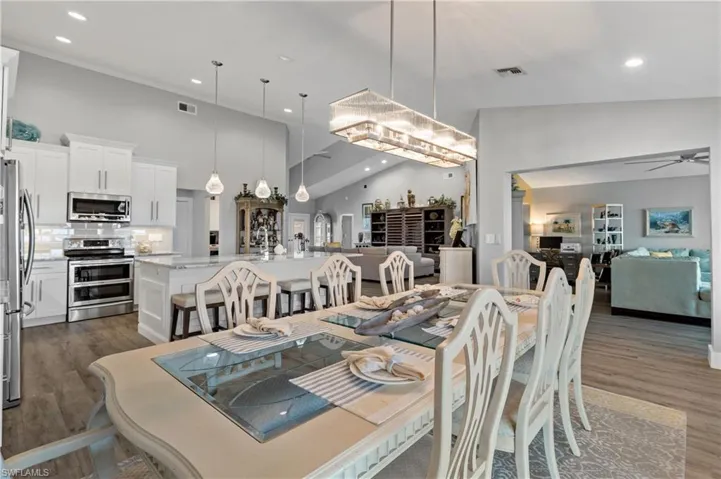 Dining space with dark hardwood / wood-style flooring, a towering ceiling, and ceiling fan