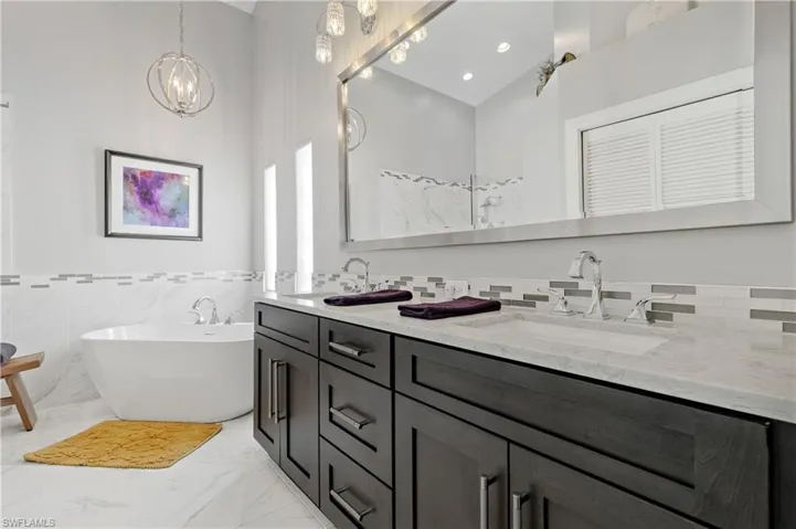 Bathroom featuring vanity, lofted ceiling, and a bathing tub