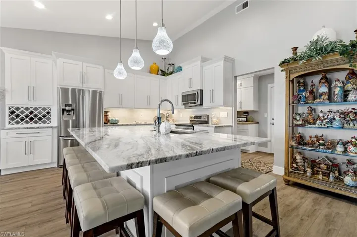 Kitchen featuring stainless steel appliances, sink, white cabinets, and a kitchen island with sink