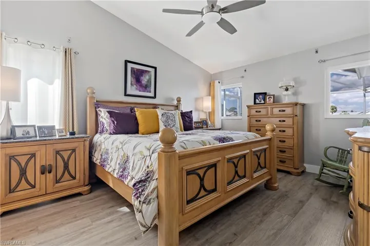Bedroom with vaulted ceiling, wood-type flooring, and ceiling fan