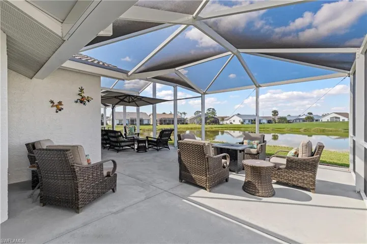 View of patio with an outdoor living space, a lanai, and a water view