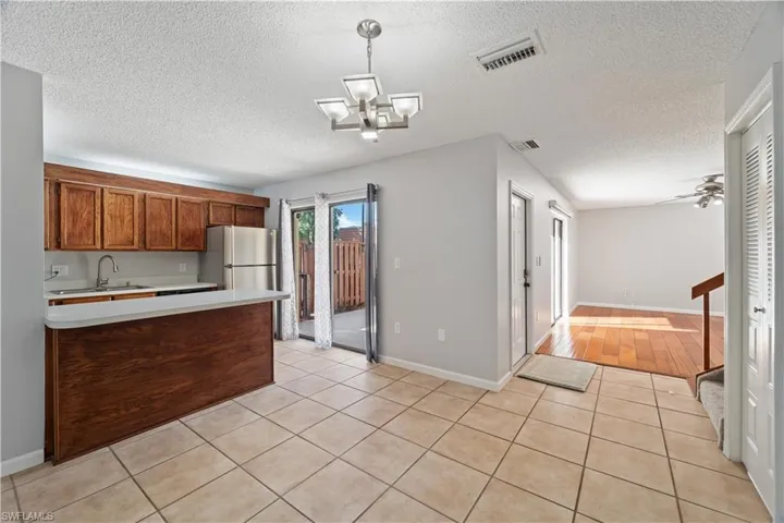 Kitchen with visible vents, a sink, light countertops, freestanding refrigerator, and a textured ceiling