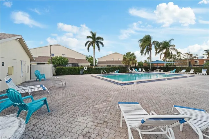 Community pool featuring a patio and fence