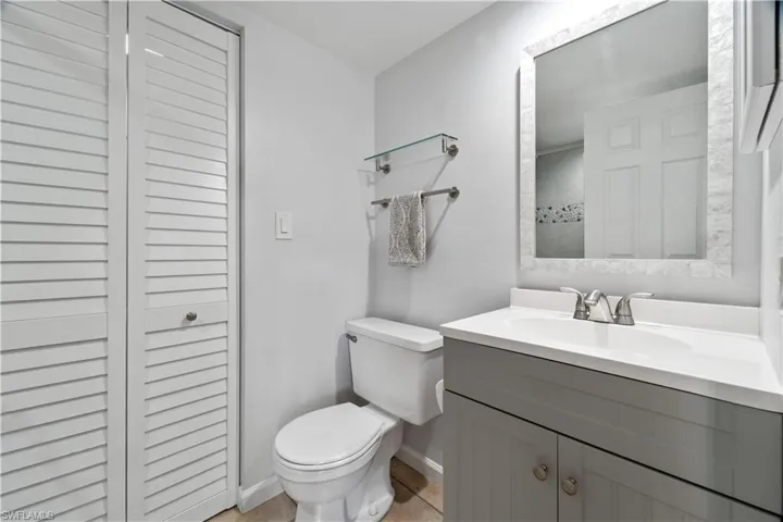 Full bathroom featuring tile patterned floors, vanity, baseboards, and toilet