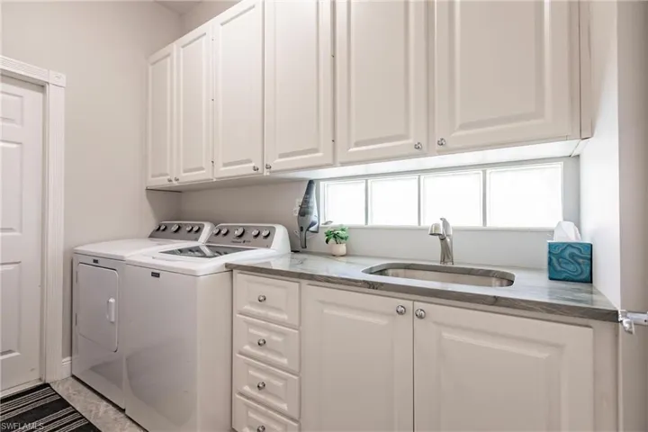 Laundry room with ample storage and sink.