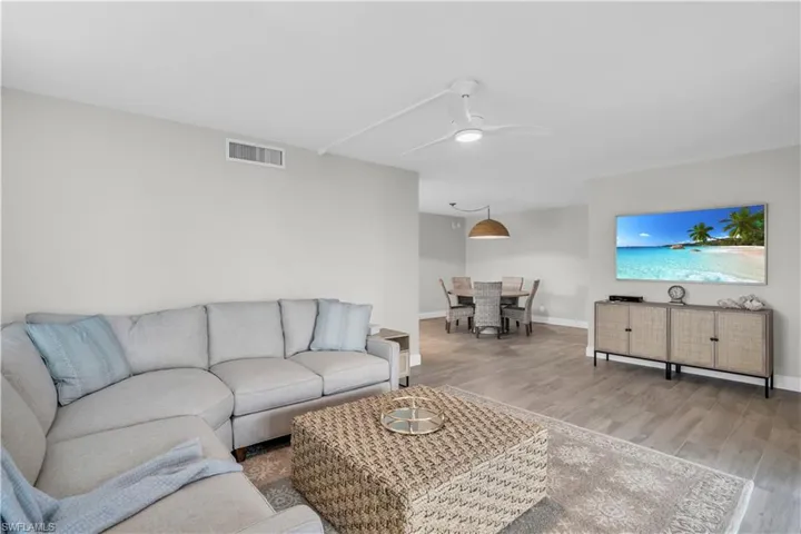 Living room with ceiling fan and hardwood / wood-style flooring